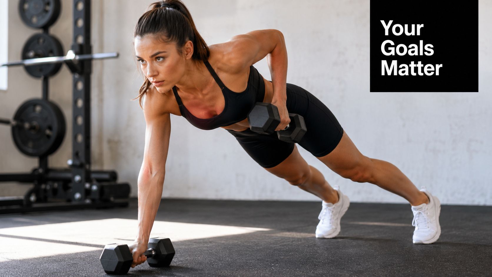 A fit woman in athletic wear performing a dumbbell renegade row exercise on a gym floor.
